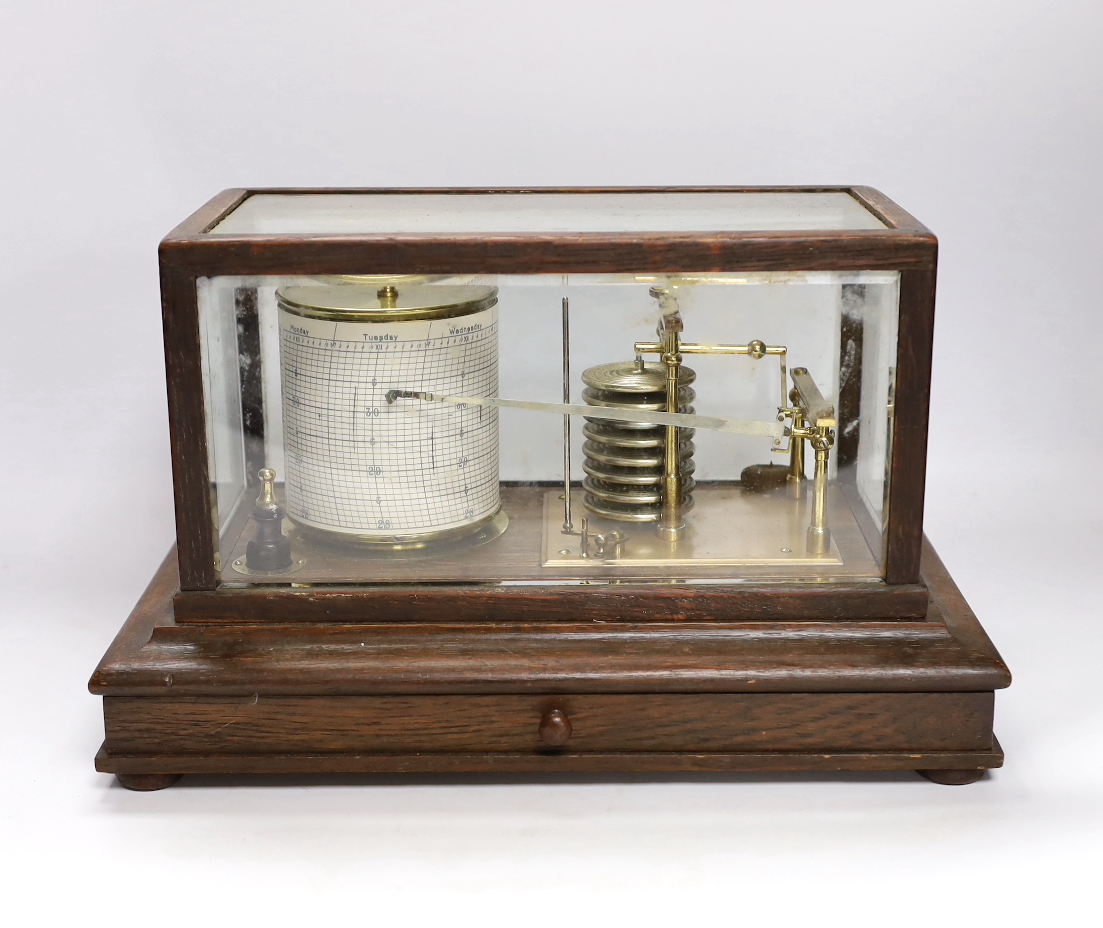 A barograph by Dollond in an oak case with bevelled glass panels and incorporating an ink bottle and a drawer with spare graph papers, 36.5cm x 21.5cm
